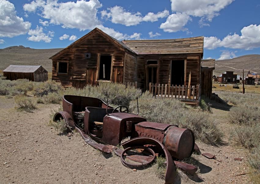 haunted house with rusted car in front