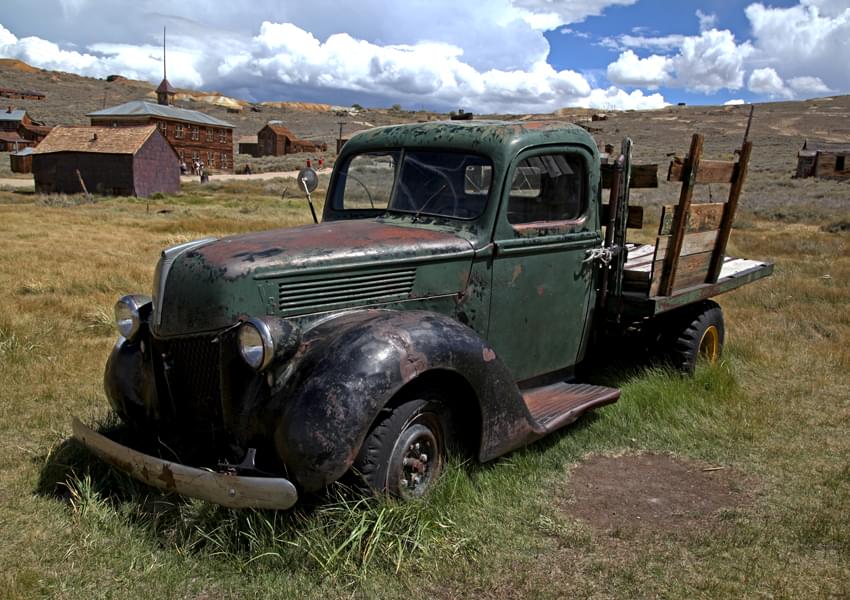 old green pick-up truck in a field