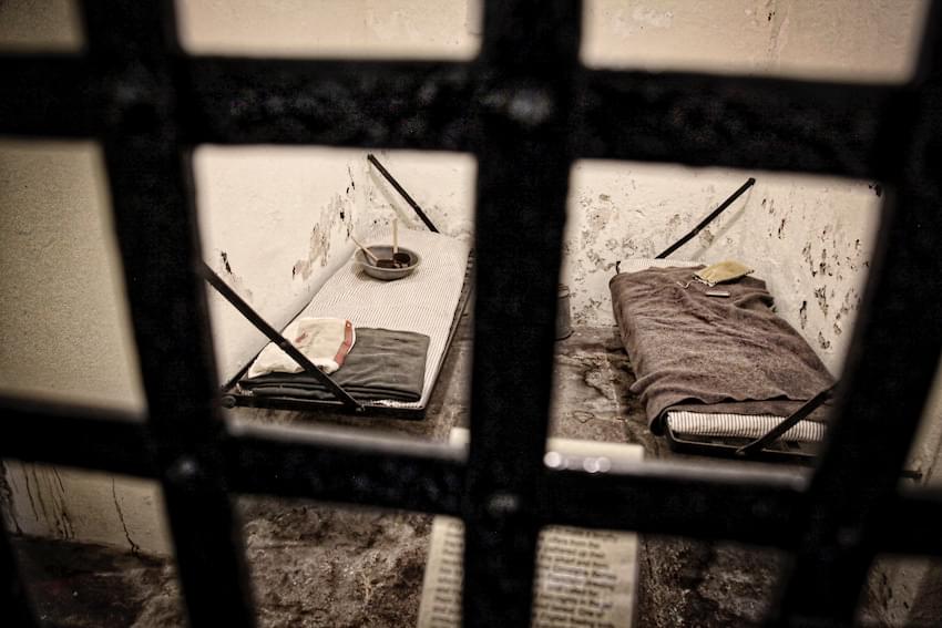 old dirty prison cell through rusted bars