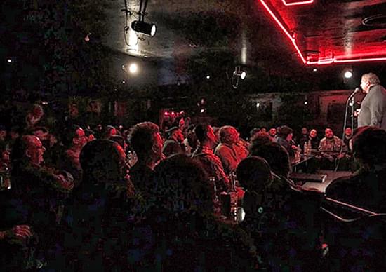 stand up comedian performing in front of a full audience