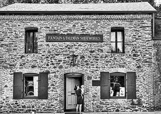 old photo of woman and child in front of large stone building