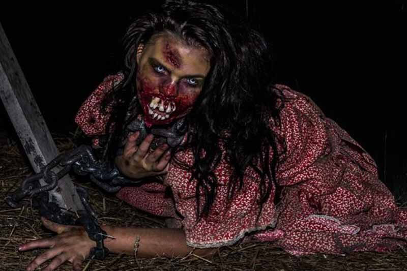 Screams Halloween Theme Park haunted house in Texas zombie girl tied by chains